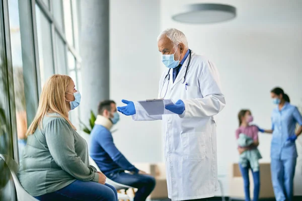 Senior Doctor Wearing Protective Face Mask While Talking Female Patient — Foto de Stock