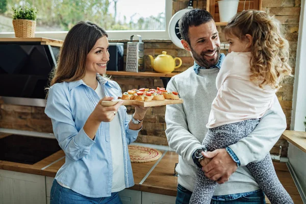 Happy Parents Talking Small Daughter While Offering Her Try Bruschetta — Fotografia de Stock