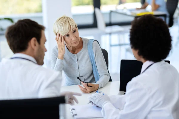 Worried Mature Woman Talking Doctors Medical Appointment Clinic — Stockfoto
