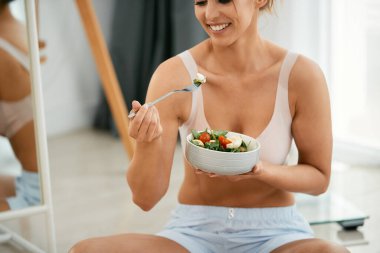 Evde salata yerken eğlenen mutlu zayıf kadın.. 