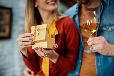 Close-up of woman opening present she has received from her boyfriend on their anniversary. 