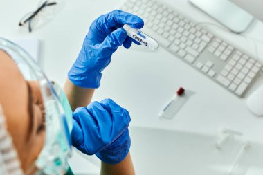 Close-up of healthcare expert analyzing coronavirus sample while working in a laboratory. 