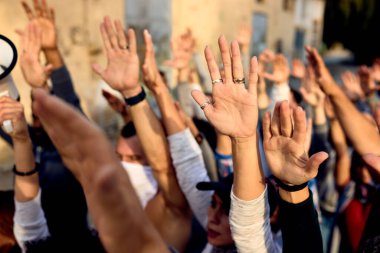 Close-up of large group of activists with raised arms on public demonstrations.