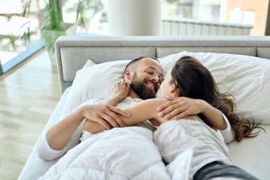 Young couple in love showing affection while communicating in the bedroom. 
