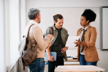 African American professor explaining test results to her adult students in the classroom.