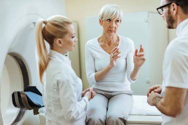 Hastahanede tomografi çektirirken doktorlarla iletişim kuran dengesiz olgun bir kadın.. 