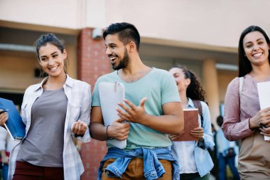 Happy university friends having fun and communicating after the lecture at campus.