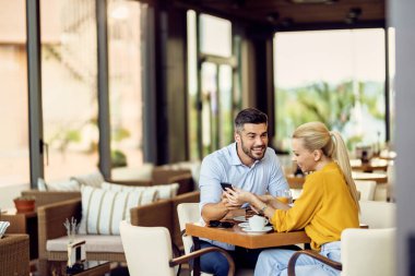 Happy couple having desert and talking while eating dessert in a cafe.  
