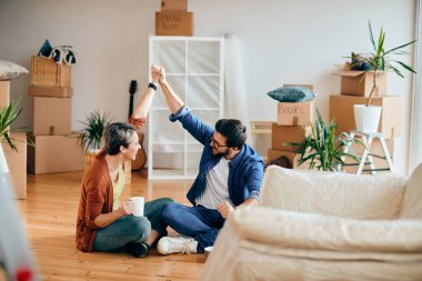 Happy couple holding hands and having fun while after becoming homeowners. 