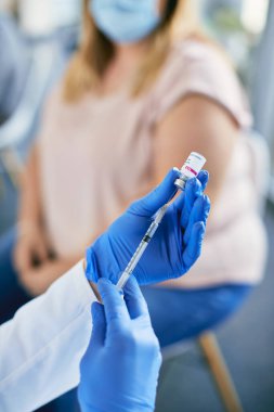 Tıbbi klinikte Coronavirus aşısı için şırınga hazırlayan doktorlara yakın çekim. 
