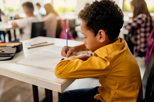 Black Elementary Student Writing Paper While Having Exam Classroom — Foto de Stock