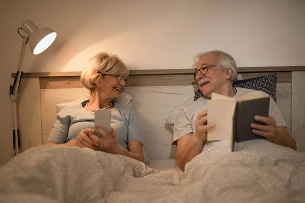 Happy Mature Couple Talking Each Other While Lying Bedroom Evening — ストック写真