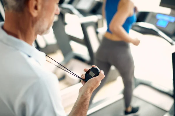 Close Personal Trainer Uses Stopwatch While Woman Runni — ストック写真