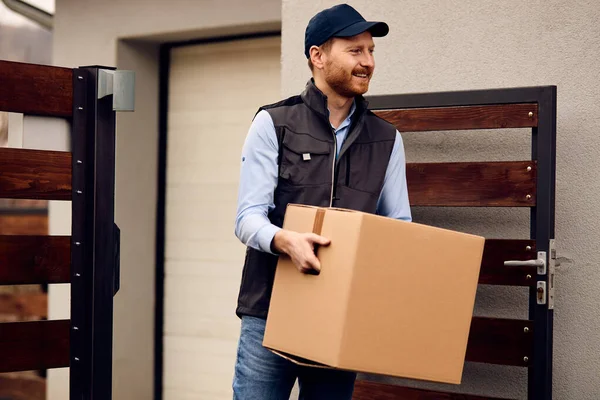 Smiling Delivery Man Carrying Cardboard Box While Making Home Delivery — Stockfoto