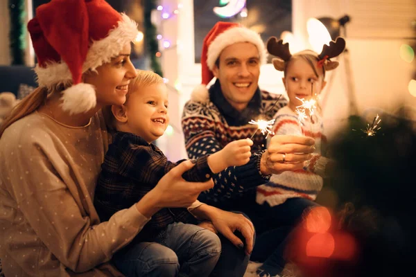 Joyful Family Enjoying Christmas Eve Having Fun Sparklers Home — Zdjęcie stockowe