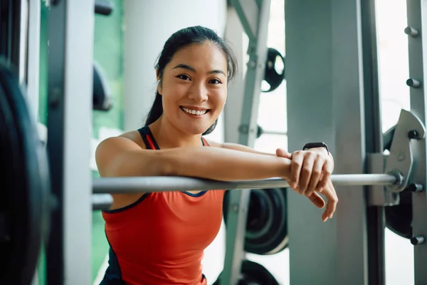 Young Happy Asian Sportswoman Taking Break While Exercising Barbell Gym — стоковое фото