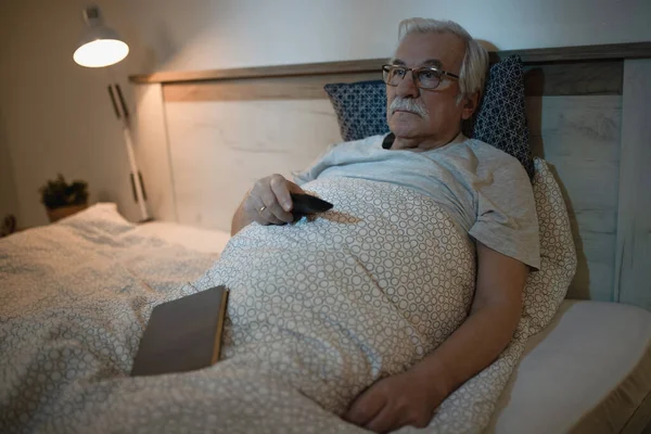 Oudere Man Ligt Bed Kijkt Nachts — Stockfoto