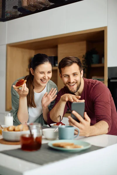 Happy Couple Using Smart Phone Waving Video Call While Eating —  Fotos de Stock