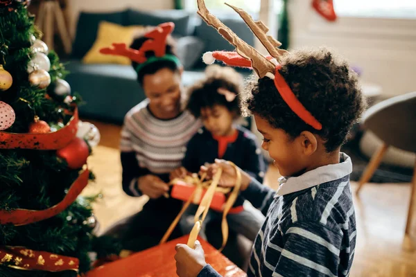 Happy African American Little Boy Unwrapping Christmas Presents Having Fun — ストック写真