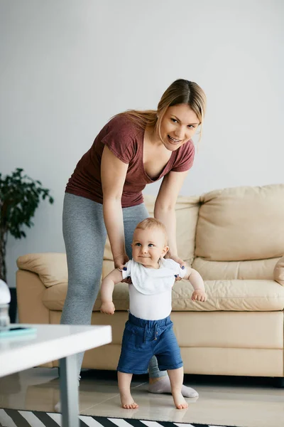 Young Mother Assisting Her Little Son His First Steps Home — Stock Photo, Image