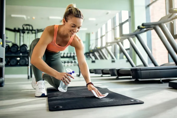 Happy Sportswoman Cleaning Exercise Mat Disinfectant Sports Training Health Club — Stockfoto