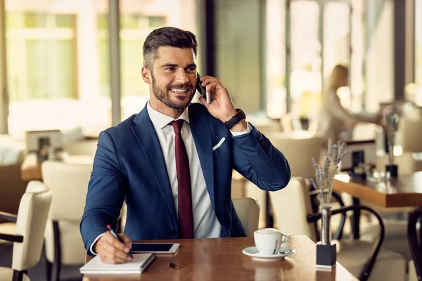 Happy Male Entrepreneur Writing Notebook While Talking Cell Phone His — Stock Fotó