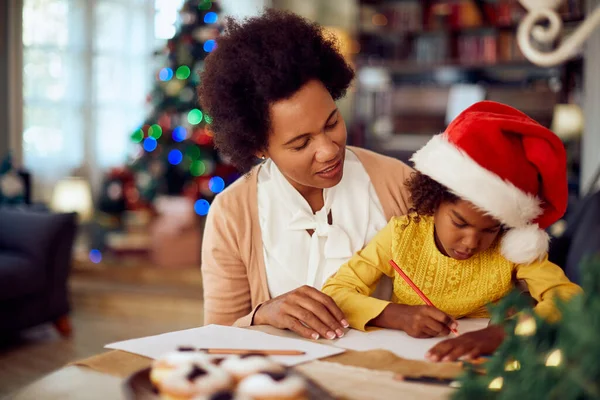 African American Mother Enjoying Christmas Her Daughter Who Drawing Something — Foto de Stock