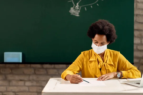 African American Teacher Wearing Protective Face Mask While Reading Students — Stok Foto