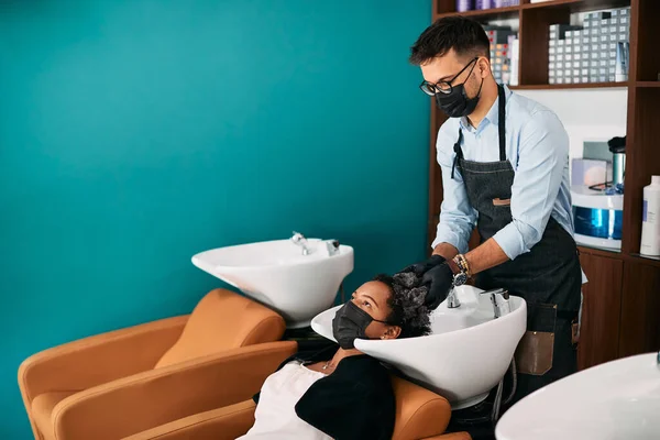 Hairstylist Wearing Face Mask While Washing African American Woman Hair — Zdjęcie stockowe