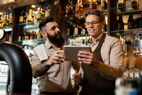 Two Happy Bartenders Cooperating While Using Digital Tablet Bar — Fotografia de Stock