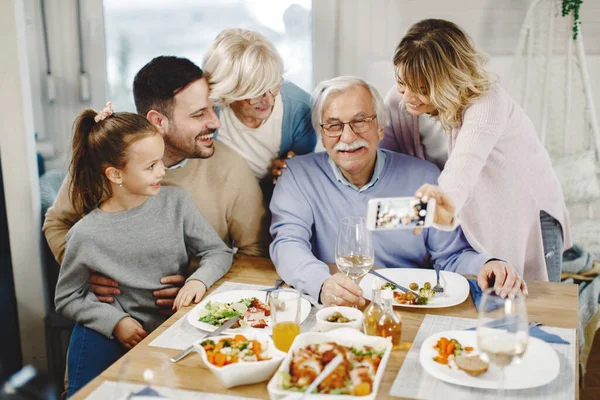 Happy Multi Generation Family Using Mobile Phone Taking Selfie Dining — Zdjęcie stockowe