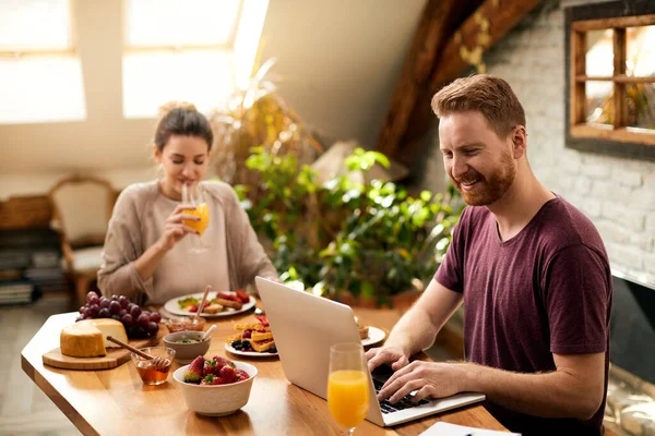 Happy Couple Having Breakfast Dining Table Focus Man Working Computer — Stock fotografie