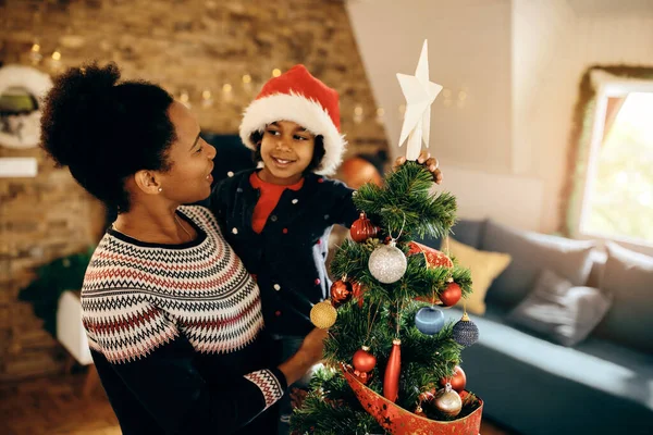 Cute Black Girl Her Mother Decorating Christmas Tree Putting Star — Foto de Stock
