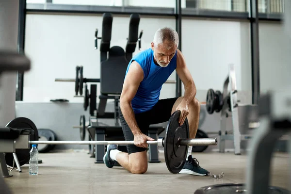 Mature Athlete Adjusts Weight Plate Barbell Strength — Fotografia de Stock