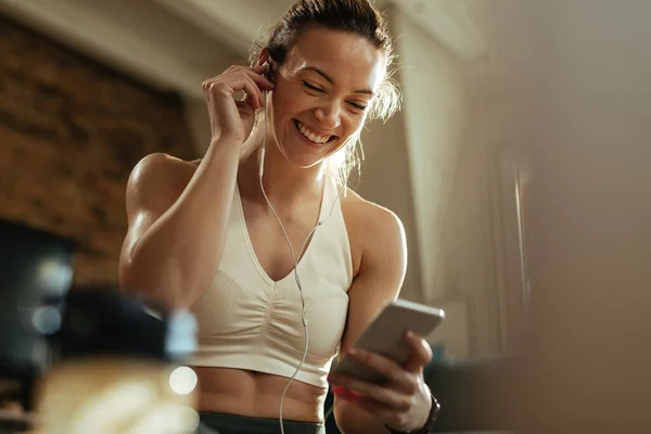 Low Angle View Happy Athletic Woman Adjusting Her Earphones While — 图库照片