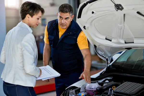 Car Mechanic Female Manager Talking While Examining Car Engine Breakdown Obraz Stockowy
