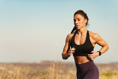 Determined sportswoman running while exercising in nature. Copy space.