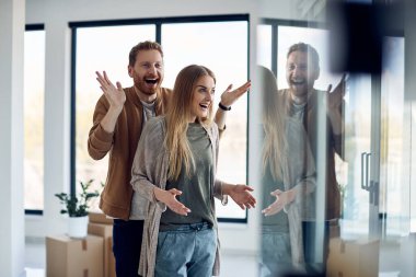 Cheerful man having fun while surprising his wife with moving into new apartment. Copy space.