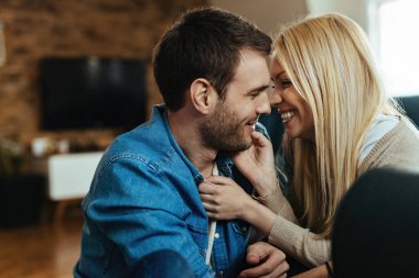 Young happy couple showing affection while being close to each other at home. 