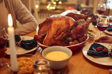 Roasted turkey on dining table during Thanksgiving meal at home.