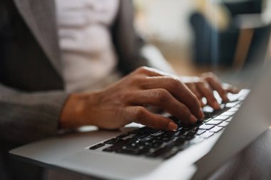 Close-up of African American businesswoman typing an e-mail while working on laptop. 