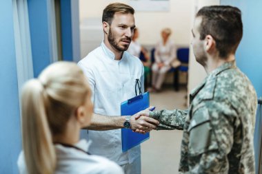 Genç bir doktor, klinikte onu karşılarken bir askerle konuşuyor.. 