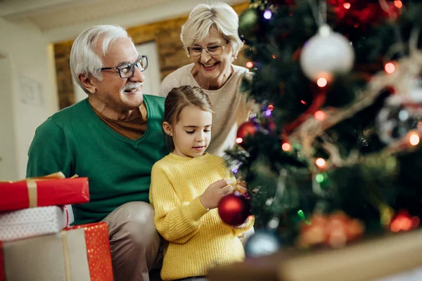 Little Girl Her Grandparents Having Fun While Decorating Christmas Tree — Zdjęcie stockowe