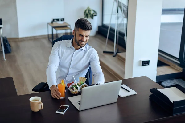 Young Happy Businessman Using Computer While Eating Healthy Food Lunch — Stock Fotó