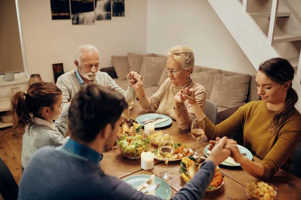 Multi Generation Family Praying Eyes Closed While Holding Hands Dining — Foto Stock