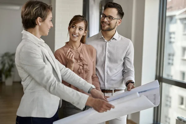Young Happy Couple Real Estate Agent Communicating While Examining Blueprints — Foto Stock