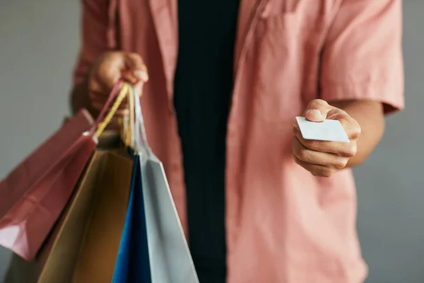 Close Black Man Holding Credit Card Shopping Bags Gray Background — Zdjęcie stockowe