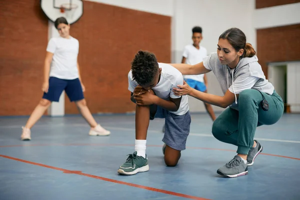 African American Schoolboy Holding His Leg Pain While Teacher Consoling — Foto de Stock