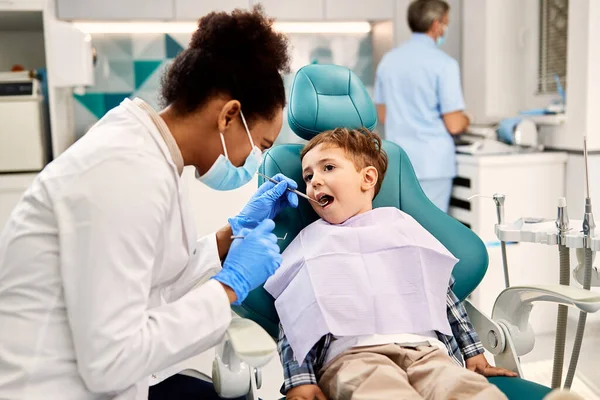 Black Female Dentist Examining Small Boy Teeth Dental Procedure Dentist — Stockfoto