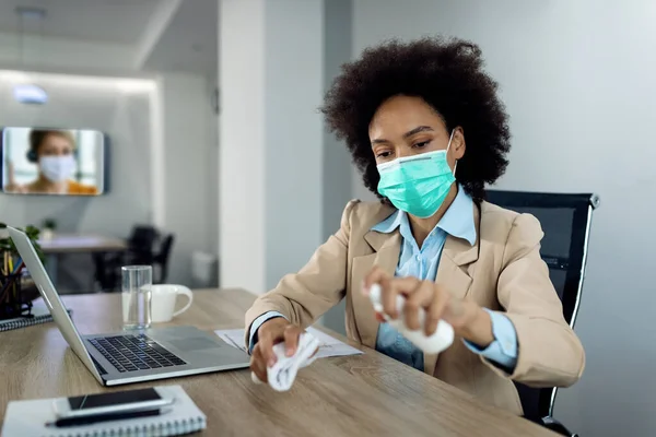 Black Businesswoman Disinfecting Office Desk Wearing Protective Face Mask Due — Foto Stock